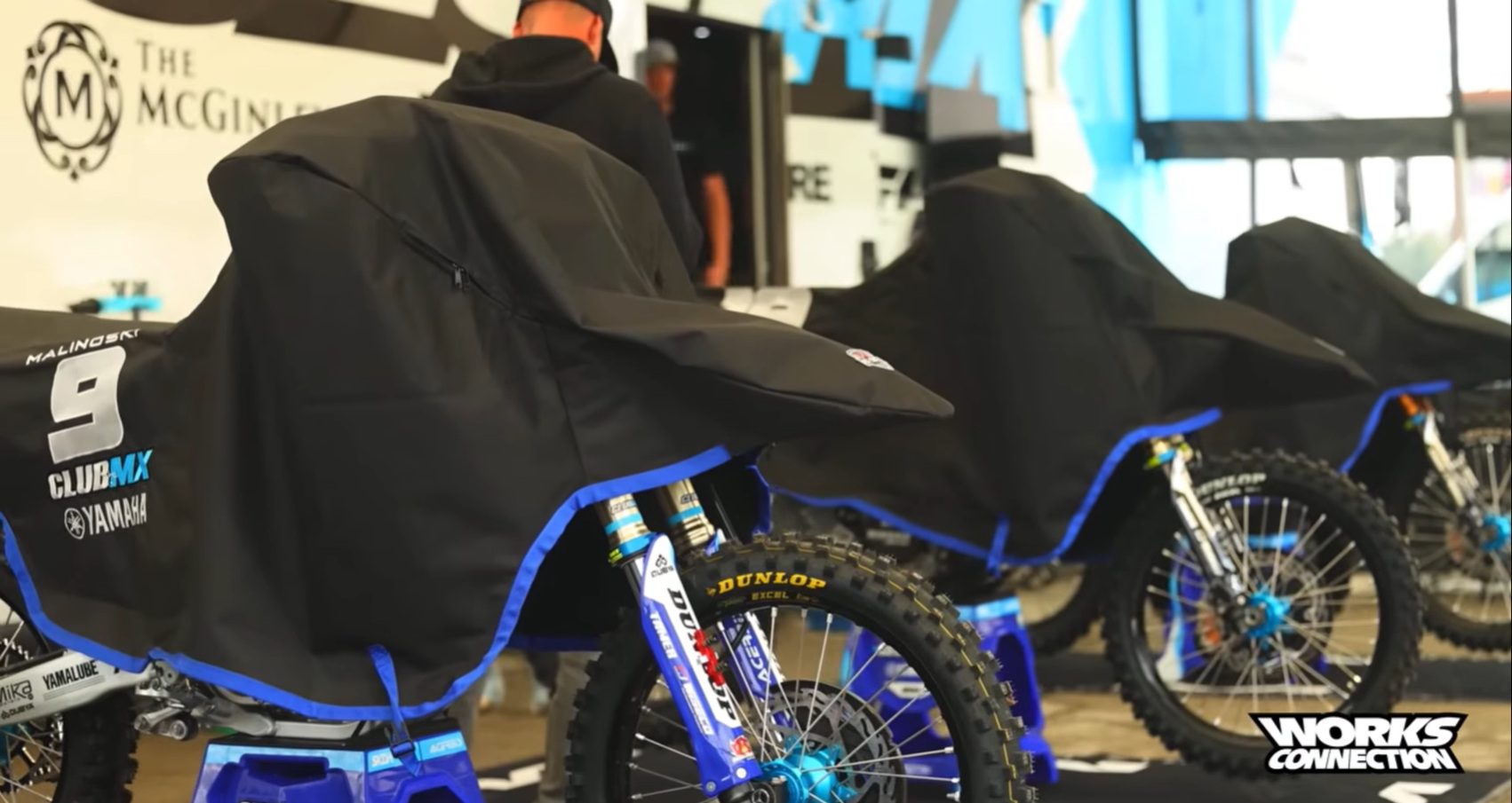 Covered blue motocross bikes in pit area