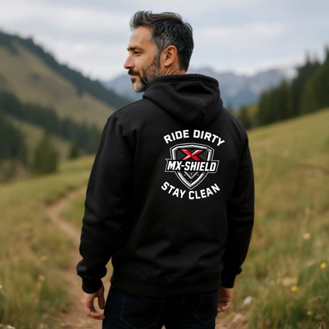 Man wearing a black hoodie with a motivational graphic on the back outdoors.